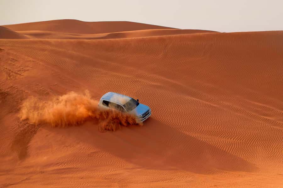 Dubai: Desert Safari, Quad Bike, Sandboarding, Camels & BBQ - Sandboarding on the Lehbab slopes