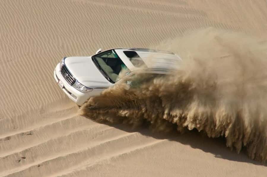 Dune Bashing, Sandboarding, Camel Ride & Optional ATV Ride - Sandboarding on the golden dunes